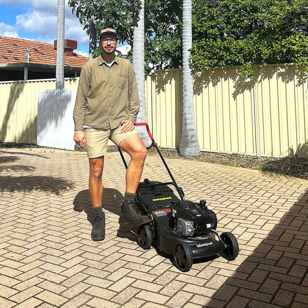 Carlos Hass with a mower on a Perth job